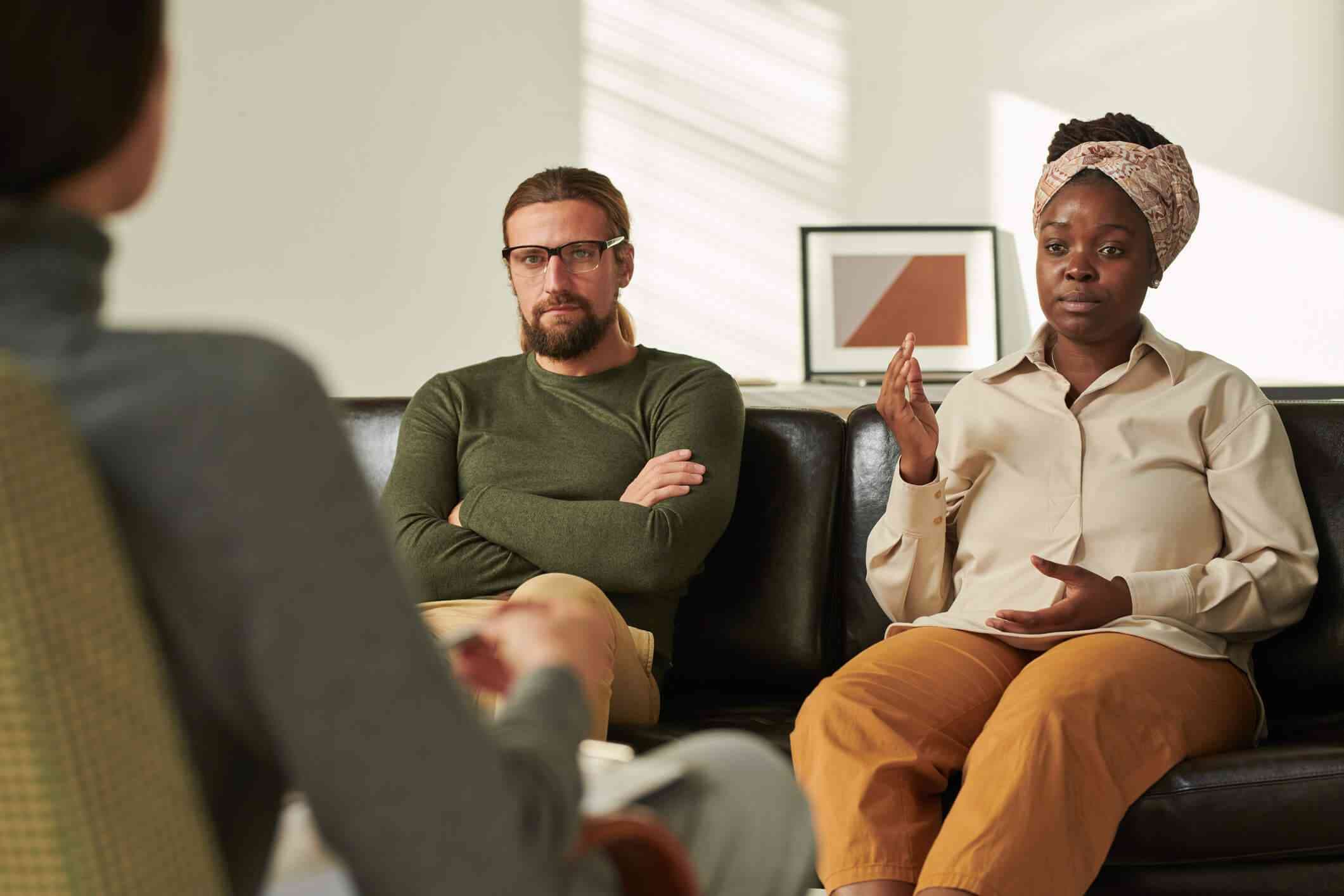 Couple sitting together processing a difficult conversation with a therapist