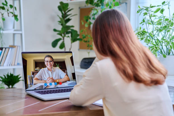 A tablet displaying a video call with a therapist, set against a vast and beautiful rural landscape view..jpg