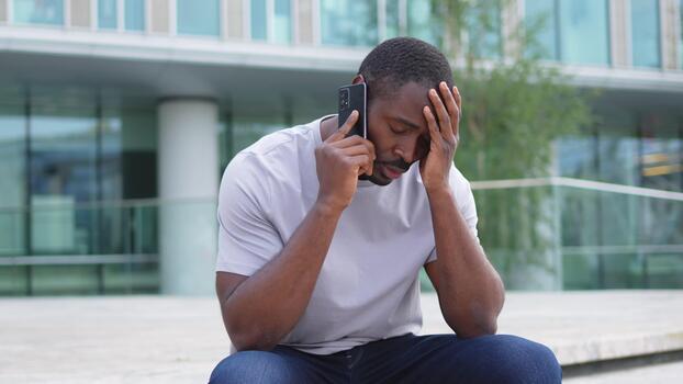 Person sitting alone after receiving difficult feedback, looking visibly upset and withdrawn